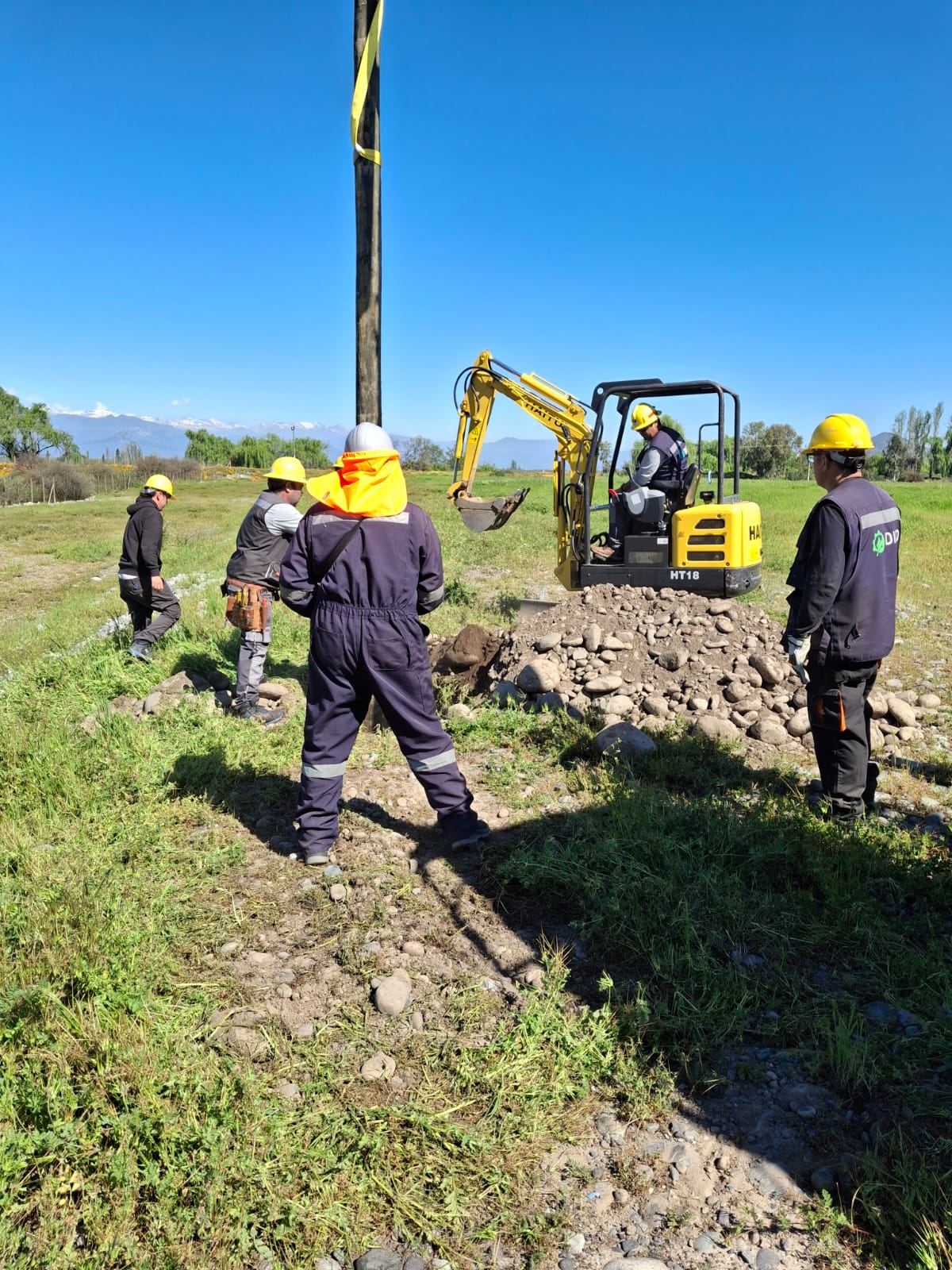 Equipo técnico de DISOR instalando poste eléctrico en terreno